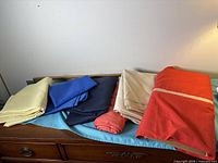 All six folded and rolled linen pieces displayed on dresser
