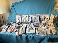 All pattern envelopes and booklets laid out on blue cloth