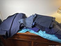 Stack of assorted navy and purple fabric on dresser