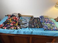 Four stacks of folded multicoloured fabrics on dresser