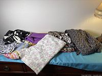 Overview of assorted folded fabric pieces on dresser