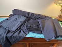 Multiple folded navy and dark blue fabrics on dresser