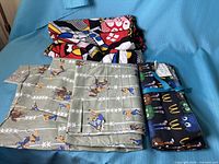 All three fabric pieces laid out: folded comic pop art, cowboy print, and bundled McDonald’s print