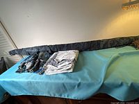 Overall lot view: roll of fabric, folded cotton cuts, heavy tapestry piece