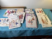 Three stacks of assorted children’s sewing patterns on table