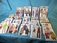 Front view showing entire lot of pattern envelopes arranged on blue fabric