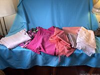 All seven folded fabric pieces laid out on blue backdrop