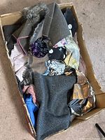 Box filled with assorted fabric pieces of various materials and colors