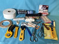 Overall view of scissors, rotary cutters, Velcro, adhesives, stabilizer rolls and notions