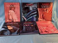All six Singer Sewing Series hardcover books displayed upright and flat