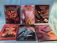 Six hardcover sewing reference books laid out front covers visible