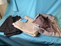 All three folded fabric pieces on blue backdrop