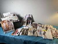 Group of sewing patterns spread on table and basket filled with more patterns