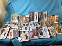 Twenty assorted women’s suit sewing patterns displayed on blue backdrop