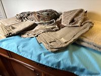 Overall view of stacked taupe and patterned fabrics on blue surface