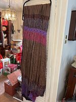 Full length view of pleated fabric hanging to show colour transitions and smocked section