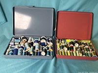 Both open cases showing thread spools sorted by color