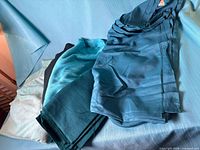 Stack of fabric pieces in various turquoise and green shades