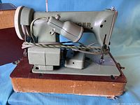 Left side view of Singer 185K machine on case base, power cord wrapped.