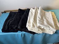 Folded black and off-white fabric lengths on table