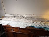 Stack of five fabric bolts on dresser, showing overall quantity and colour range