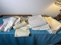Overview of assorted white and cream fabric pieces on blue surface