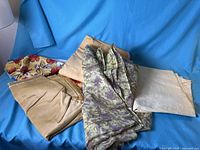 Group of five yellow fabrics in assorted patterns and textures displayed on blue background