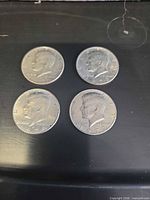 Obverse of four Kennedy half dollars
