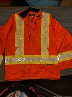 Full view of front of orange hi-vis jacket with reflective tape