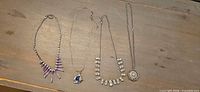 Group shot of all four necklaces laid flat