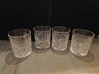 Group of four matching cut crystal lowball glasses showing overall design and quantity