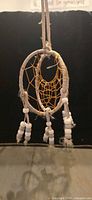 Front view of dreamcatcher showing hoop, web, bead and feather tassels