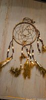 Front view of the dreamcatcher showing hoop, web, beads, and feathers