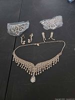 Full set laid out showing necklace, three earring pairs and two wrapped hair combs