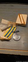 Medal, ribbon, mounting bar and box on table