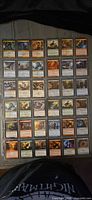Binder page showing six rows of sleeved Magic: The Gathering cards
