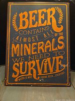 Front of metal sign showing full beer quote and design