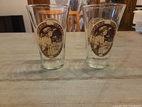Front view of both pint glasses showing Coca-Cola lady graphic