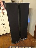 Two black Polk T50 tower speakers standing side by side