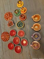 All 18 multicolor terracotta candle holders grouped on surface