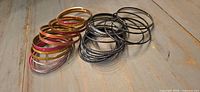 Group of over twenty assorted metal bangles showing color variety and style