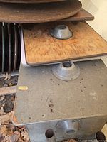 Stack of square and round table tops showing metal center flanges