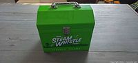 Front view showing Steam Whistle branding, latch and handle