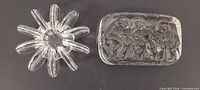 top view of both clear glass items: paperweight showing three figures and starburst votive