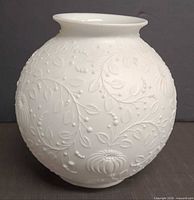Full side view of spherical white embossed porcelain vase