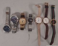 All seven wristwatches side by side showing overall condition and band types