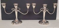 Front view of pair of silver-plated 3-arm candelabra