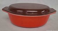 Side view of assembled casserole showing pink base and brown lid