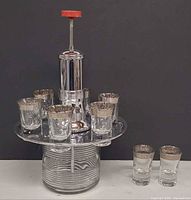 Front view of full carousel set with glasses in holder and two extra glasses beside
