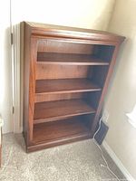 Front view of wooden 4-shelf bookcase showing shelves and finish
